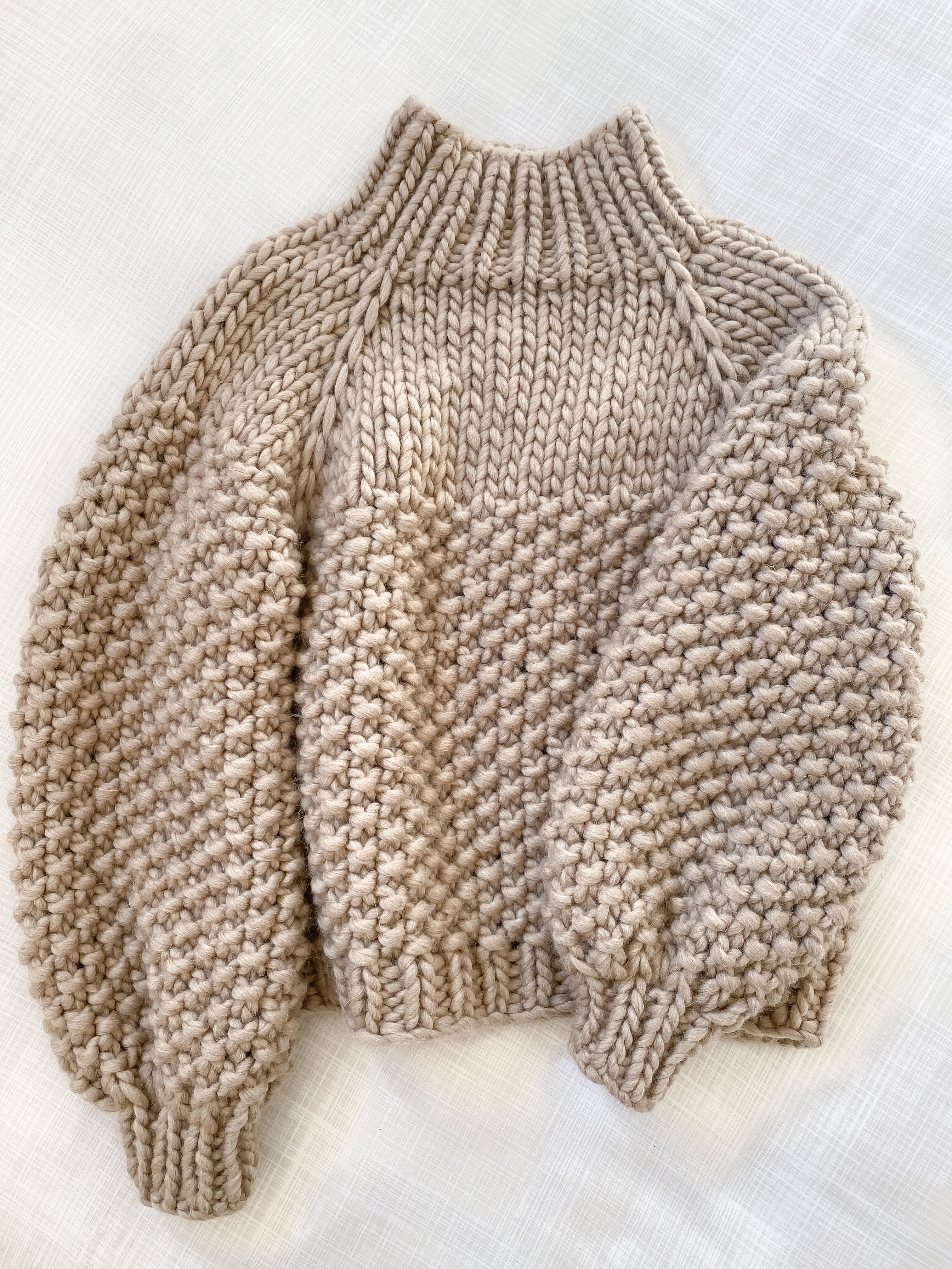 Beige chunky knitted sweater on a light background